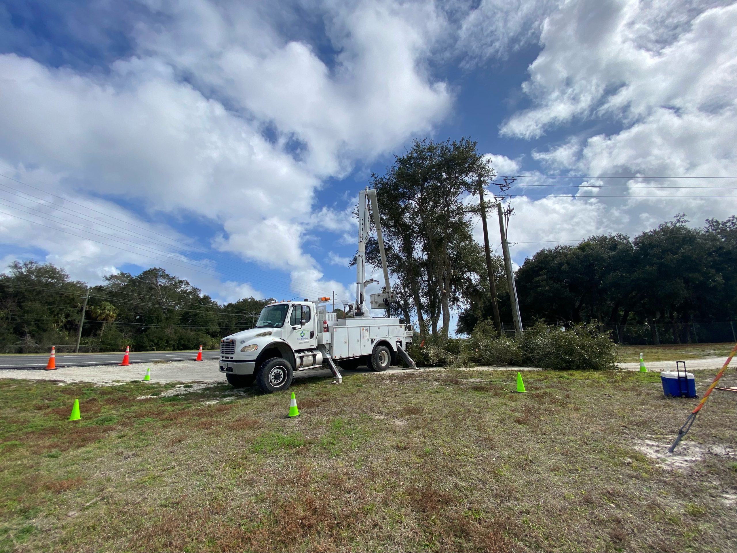 4x4 bucket truck staged with safety cones under power lines