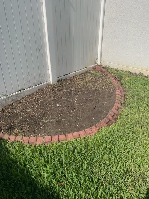Area leveled after stump grinding near a brick border