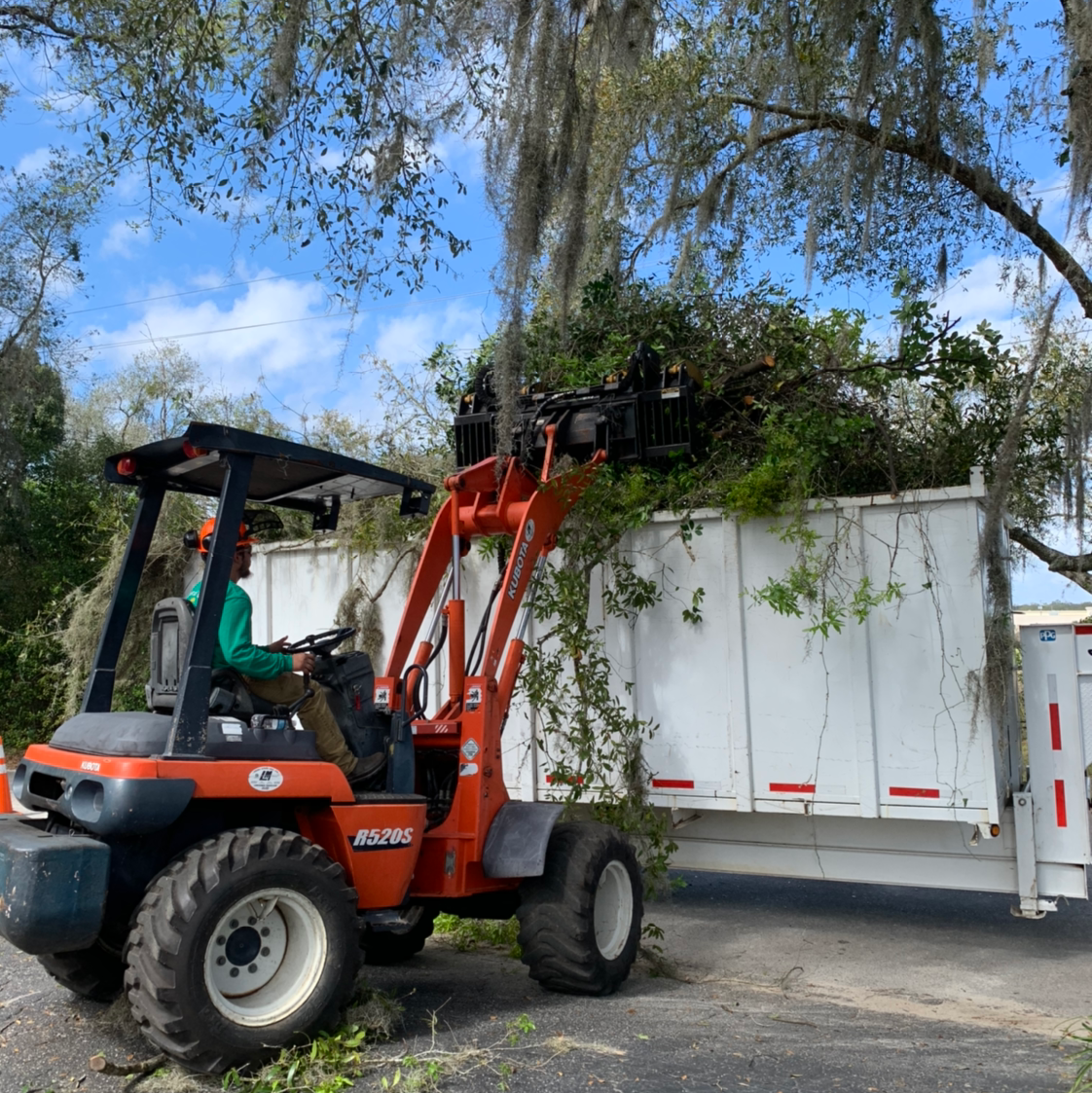Kubota loader dumping brush into container