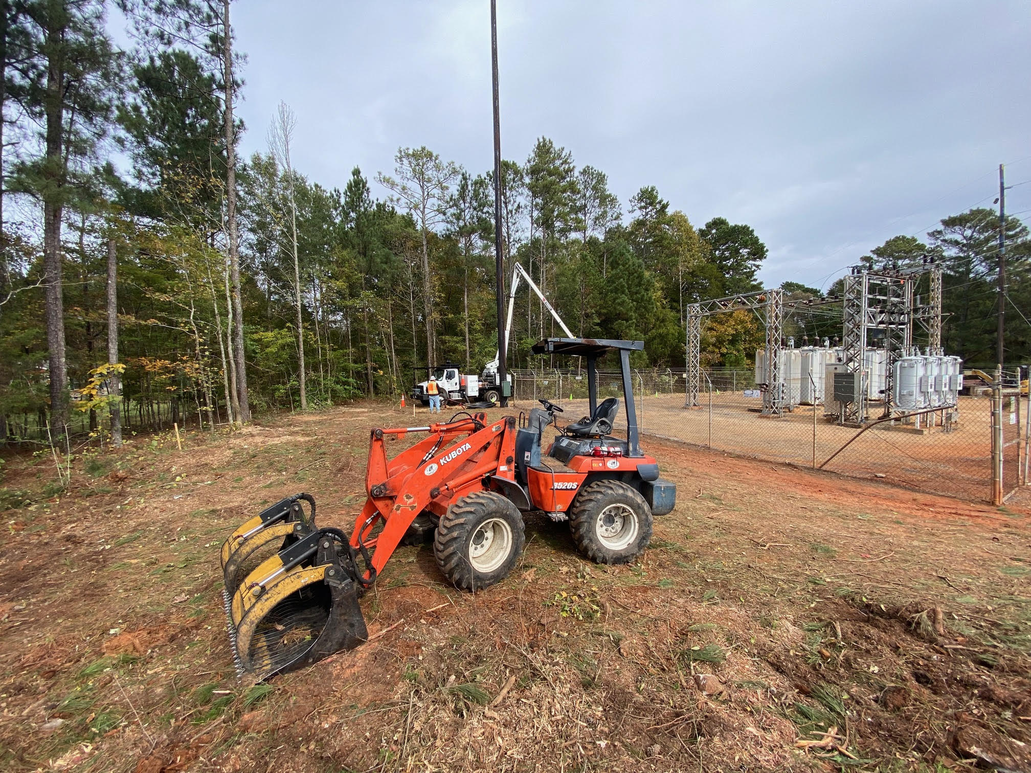 Kubota loader clearing large debris pile